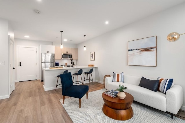 living area with light wood-style floors, recessed lighting, and baseboards