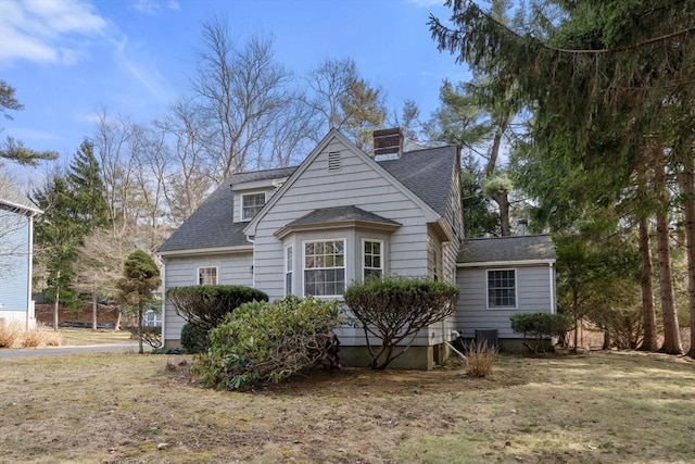 view of front of home with central air condition unit and a shingled roof