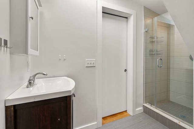 full bath with tile patterned floors, baseboards, vanity, and a shower stall