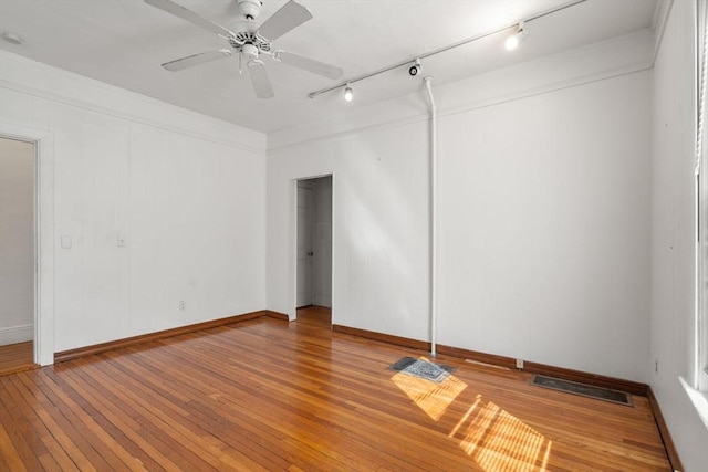 unfurnished room with visible vents, light wood-style flooring, baseboards, and a ceiling fan