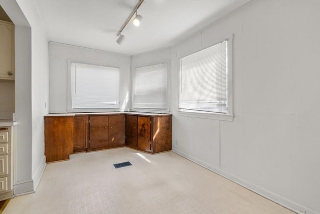 unfurnished room with track lighting and visible vents