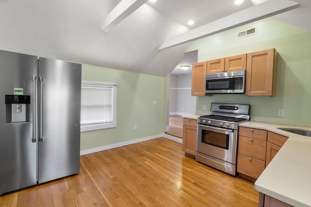 kitchen featuring stainless steel appliances, visible vents, light countertops, and vaulted ceiling