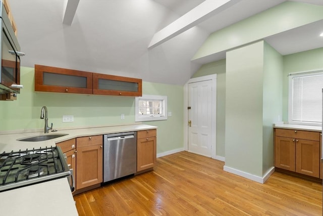 kitchen featuring baseboards, a sink, light countertops, dishwasher, and light wood-type flooring