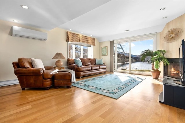 18 Hawkswood Ests Unit 18, Amesbury, MA 01913 - living room with a fireplace with flush hearth, an AC wall unit, recessed lighting, and light wood-style floors