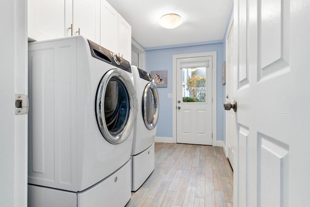 18 Hawkswood Ests Unit 18, Amesbury, MA 01913 - laundry area featuring baseboards, washing machine and clothes dryer, cabinet space, and light wood-style flooring