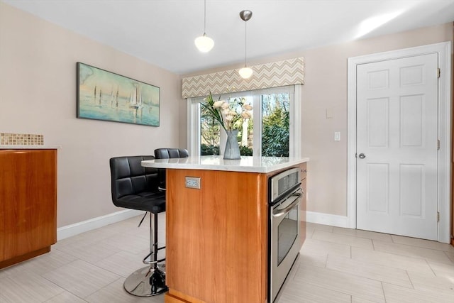 18 Hawkswood Ests Unit 18, Amesbury, MA 01913 - kitchen with light countertops, baseboards, brown cabinets, and a breakfast bar area