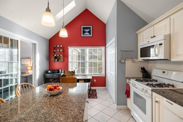 kitchen featuring white appliances, a wealth of natural light, hanging light fixtures, and backsplash