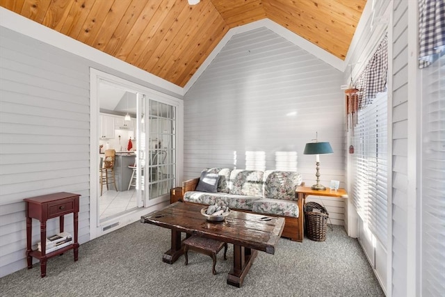 carpeted living room with lofted ceiling, a wealth of natural light, wooden ceiling, and wooden walls