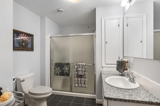 bathroom featuring vanity, toilet, a shower with shower door, and tile patterned flooring