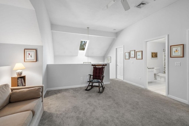 living area featuring ceiling fan, vaulted ceiling, and light carpet