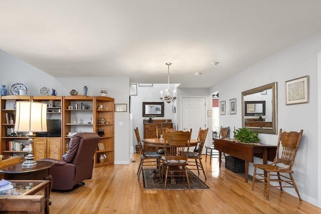 dining area with a notable chandelier and light hardwood / wood-style flooring