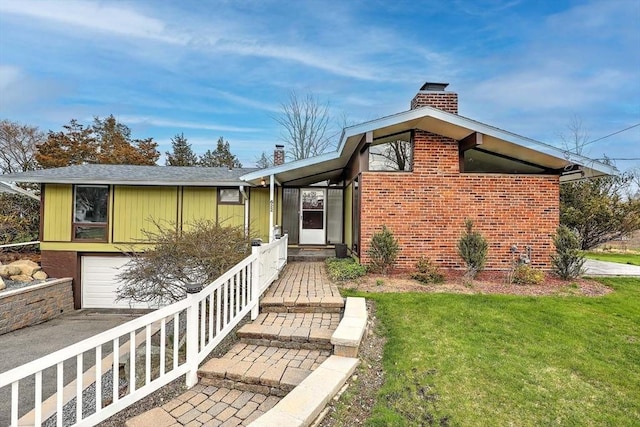 622 Pike Ave, Attleboro, MA 02703 - view of front of house featuring a chimney, brick siding, a front yard, concrete driveway, and an attached garage
