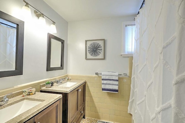 622 Pike Ave, Attleboro, MA 02703 - full bathroom featuring tile walls, wainscoting, two vanities, and a sink