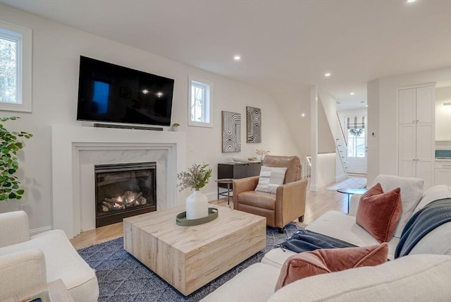 living area featuring light wood finished floors, a fireplace, and recessed lighting