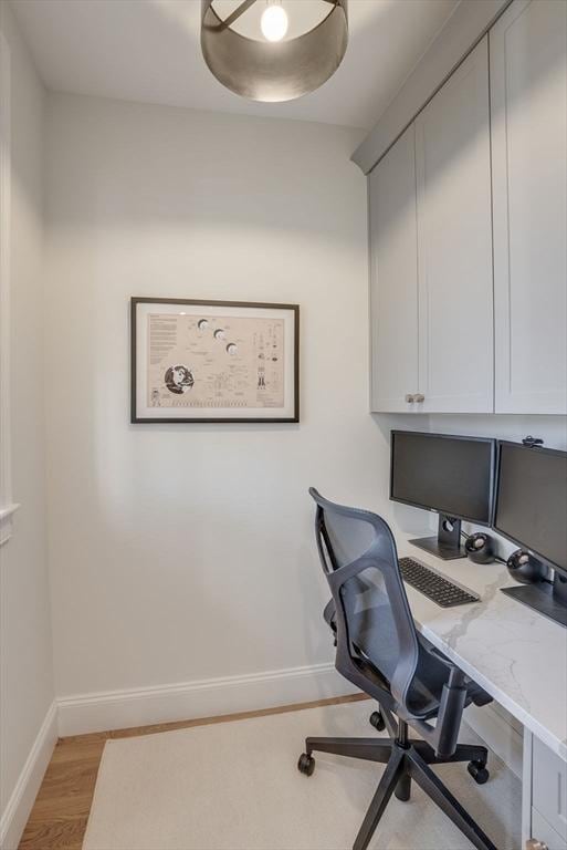 office space with light wood-style floors and baseboards