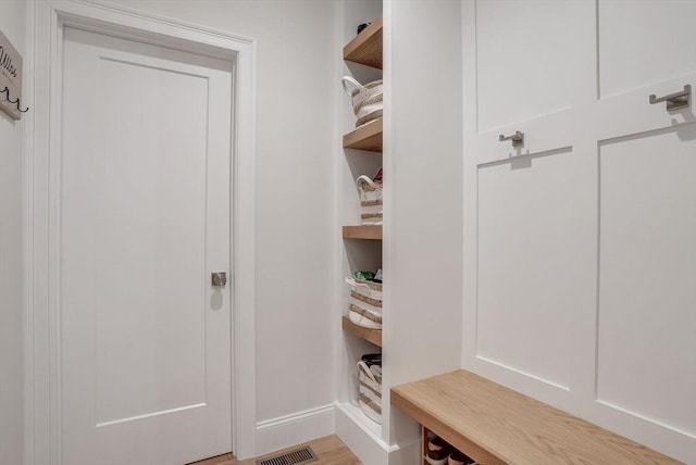 mudroom with baseboards, visible vents, and light wood finished floors