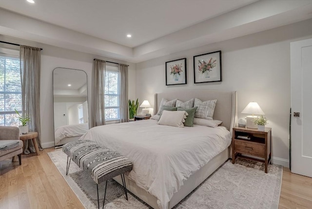 bedroom featuring light wood finished floors, recessed lighting, and baseboards