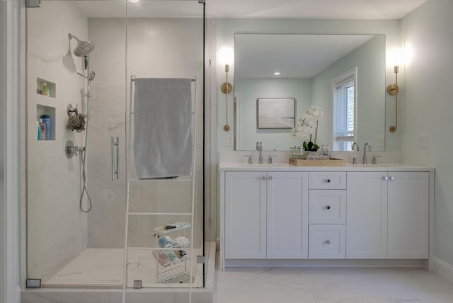 full bathroom featuring marble finish floor, a sink, a shower stall, and double vanity