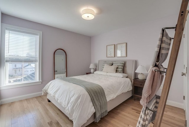 bedroom featuring light wood-style flooring and baseboards