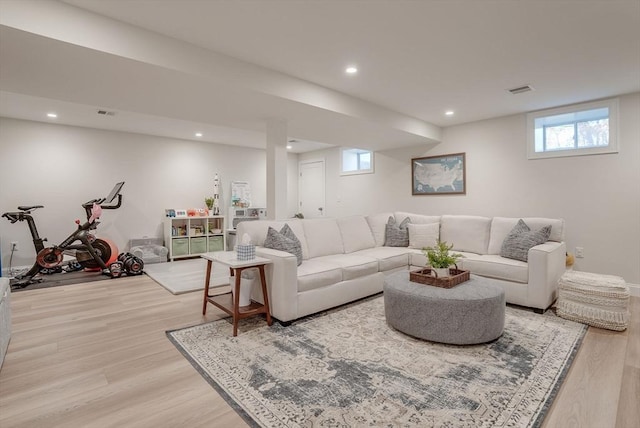 living room with light wood-style flooring, visible vents, and recessed lighting