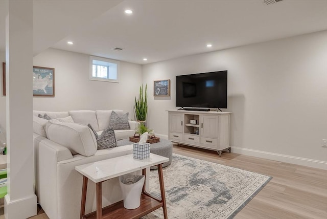 living area with light wood-style floors, recessed lighting, visible vents, and baseboards