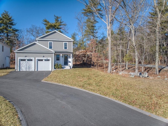 traditional-style house featuring a front lawn, driveway, and an attached garage