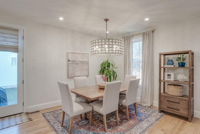 dining space featuring light wood-style flooring, recessed lighting, a notable chandelier, visible vents, and baseboards