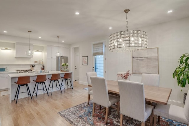 dining space with recessed lighting, baseboards, light wood finished floors, and an inviting chandelier