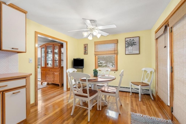 dining area with a ceiling fan and light wood-style flooring