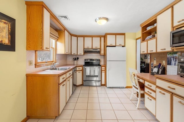 kitchen with visible vents, stainless steel appliances, light countertops, under cabinet range hood, and a sink