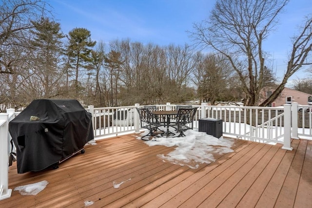 snow covered deck featuring grilling area and outdoor dining space