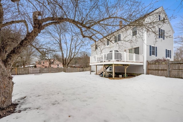 yard covered in snow with stairway, fence, and a wooden deck