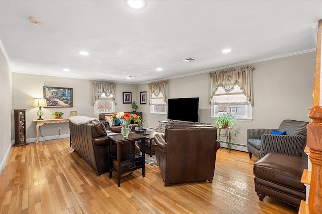 living area featuring visible vents, light wood-style flooring, baseboard heating, ornamental molding, and baseboards