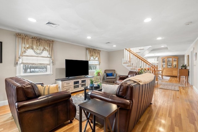 living area featuring light wood-type flooring, crown molding, stairway, and recessed lighting