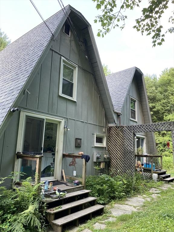 rear view of property with roof with shingles and board and batten siding