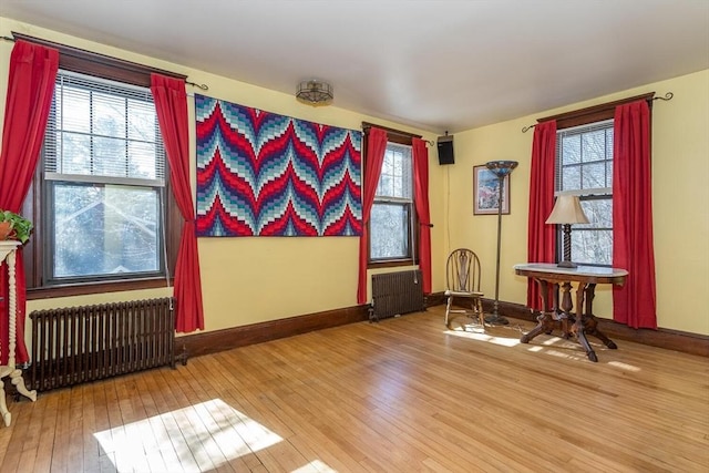 interior space featuring radiator, baseboards, and hardwood / wood-style flooring