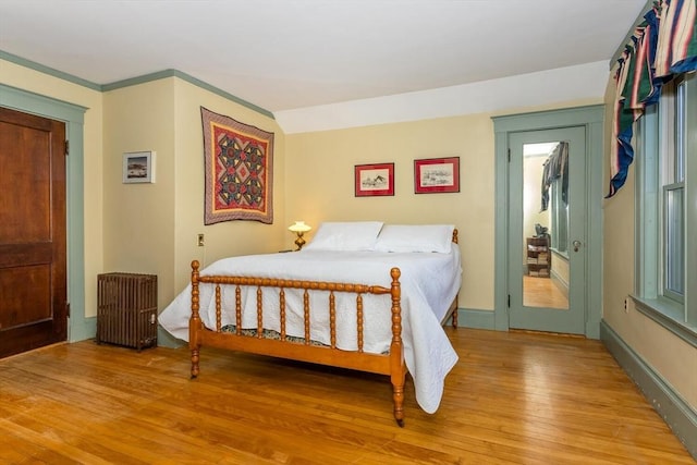 bedroom with radiator and light wood-type flooring