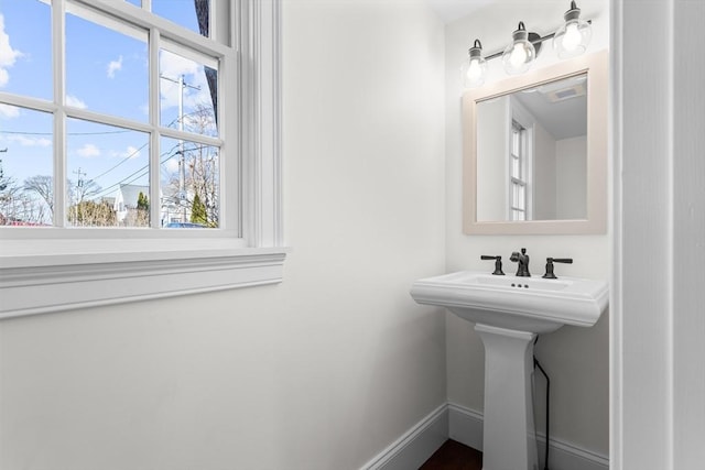 bathroom with a sink and baseboards