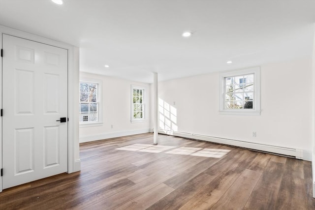 empty room with recessed lighting, wood finished floors, baseboards, and a baseboard radiator