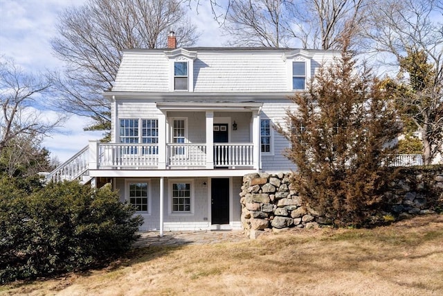 view of front facade featuring a front lawn and a chimney