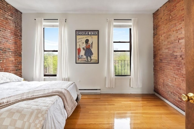17 Dwight Unit 3, Boston, MA 02118 - bedroom featuring baseboard heating, brick wall, multiple windows, light wood-type flooring, and baseboards