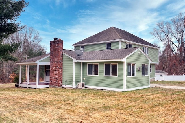 rear view of house featuring a yard and ac unit