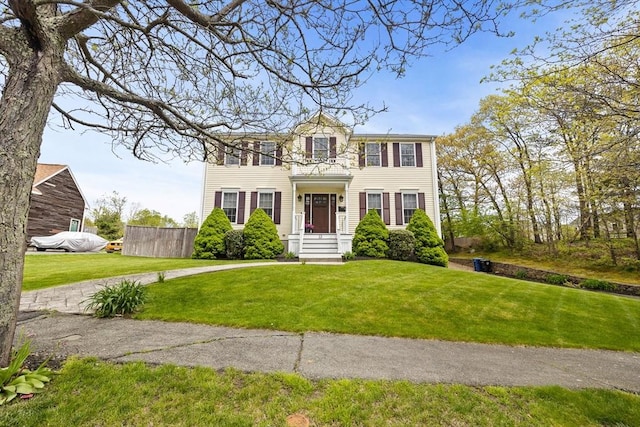 colonial home featuring a front lawn