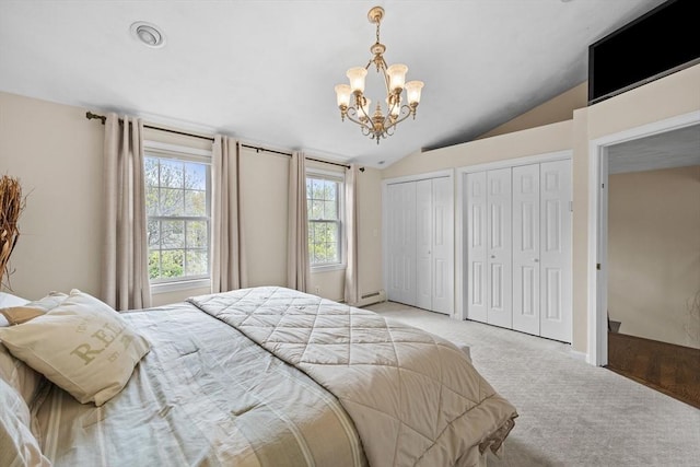 bedroom featuring multiple closets, carpet flooring, vaulted ceiling, and a chandelier