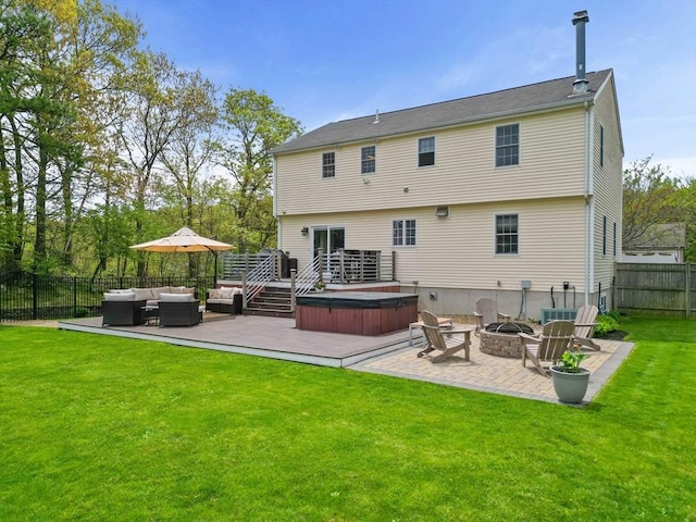 rear view of property featuring a hot tub, an outdoor living space with a fire pit, a patio, and a wooden deck