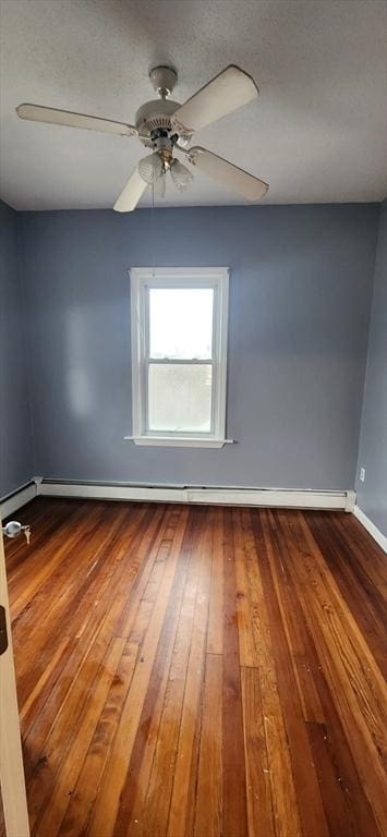 empty room featuring a textured ceiling, a baseboard heating unit, dark wood-style flooring, a ceiling fan, and baseboards