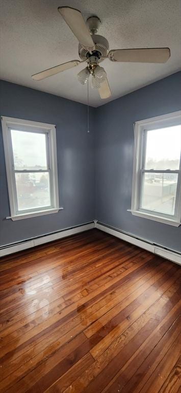 spare room featuring dark wood-style flooring, ceiling fan, a textured ceiling, and baseboard heating