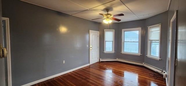 empty room with dark wood-style floors, a ceiling fan, and baseboards