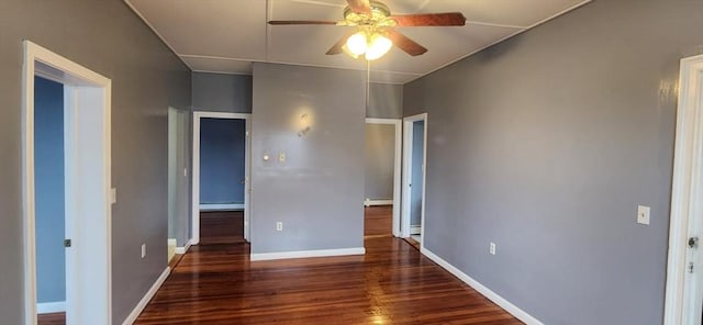 spare room with a baseboard heating unit, baseboards, a ceiling fan, and wood finished floors