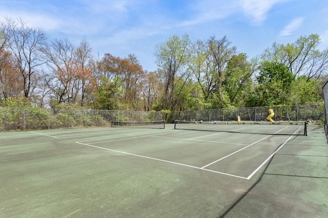 view of tennis court featuring fence